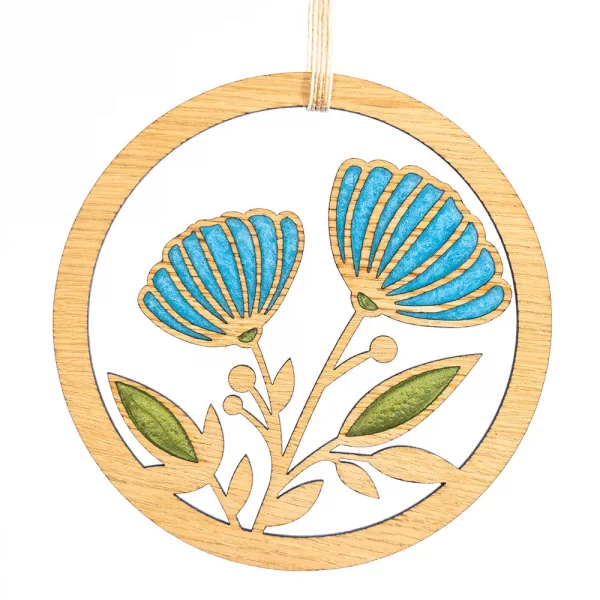 Image showing a circular wooden laser cut decoration featuring flowers and leaves filled with colourful resins. Designed and handcrafted in Scotland by Kyloe Creations.